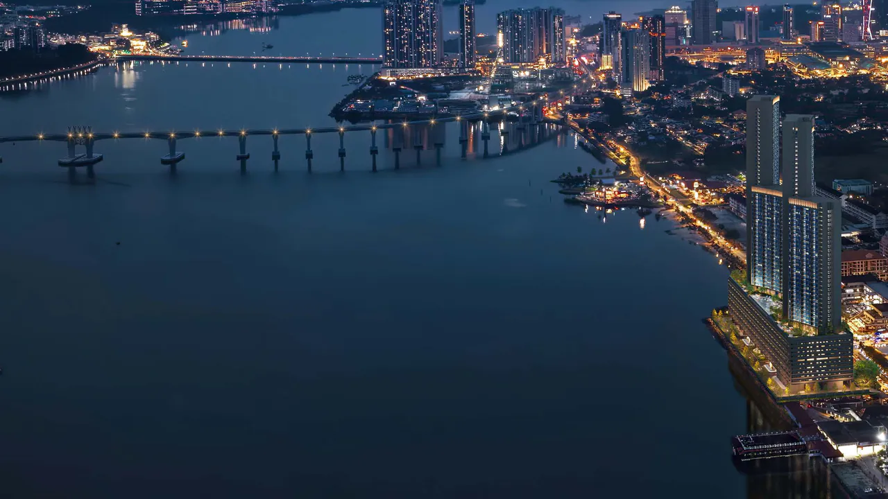 The Straits of Johor at night: the RTS Link viaduct across the water, the lit towers of The Eclipse and the Johor Bahru shore (photograph with CGI of the proposed towers)